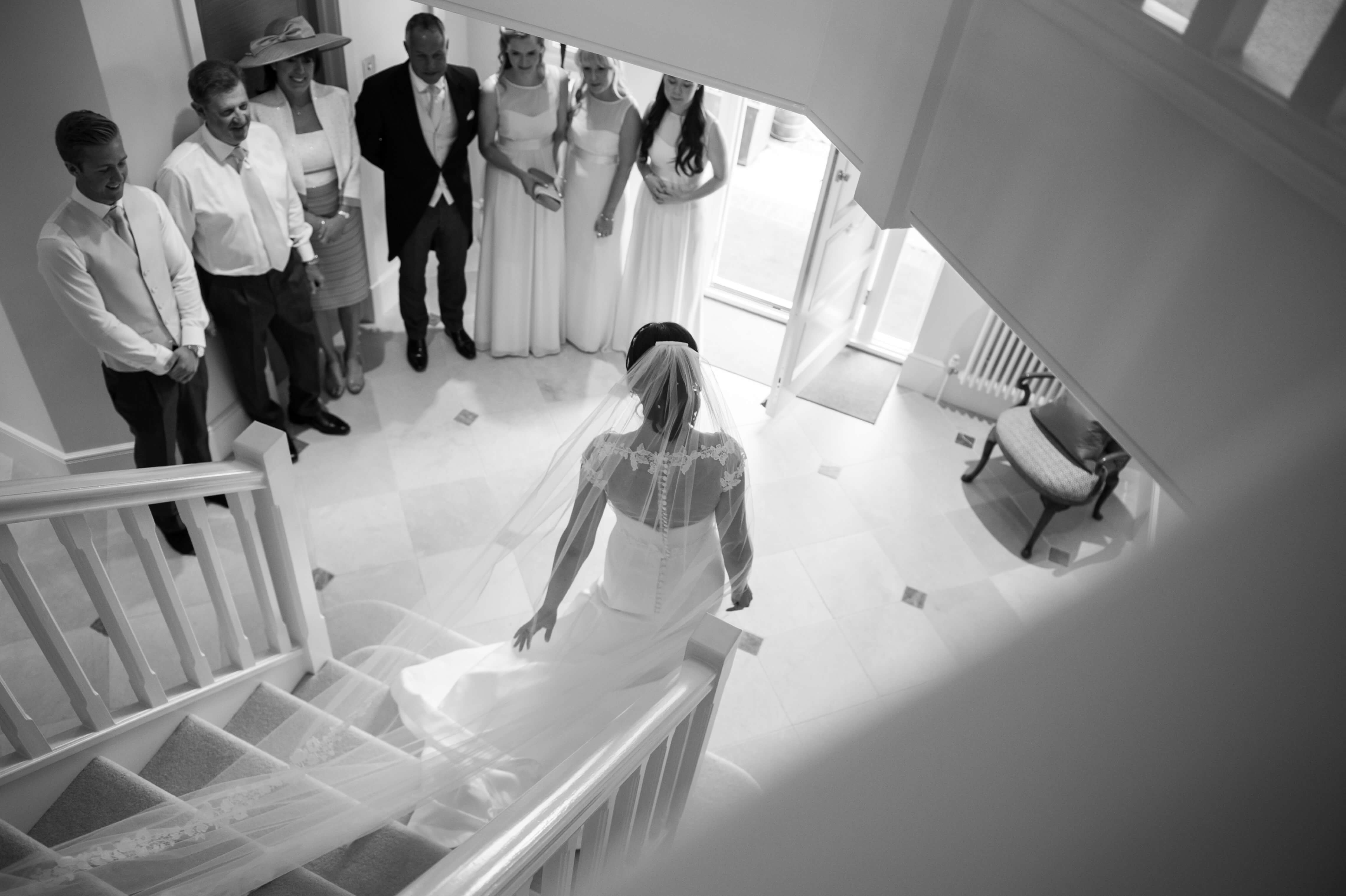 bride walking down the stairs in her caroline castigliano wedding dress in esher surrey